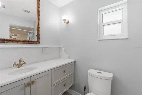 a bathroom with a toilet a sink a vanity and mirror