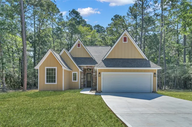 a view of front a house with a yard and garage