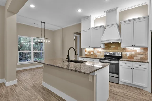 a kitchen with granite countertop a sink stainless steel appliances and cabinets