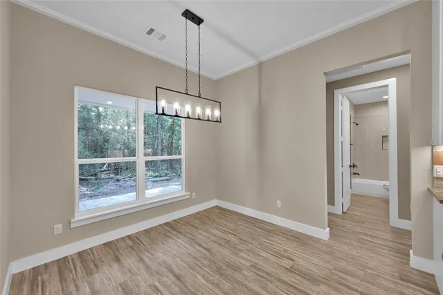 a view of empty room with wooden floor and window
