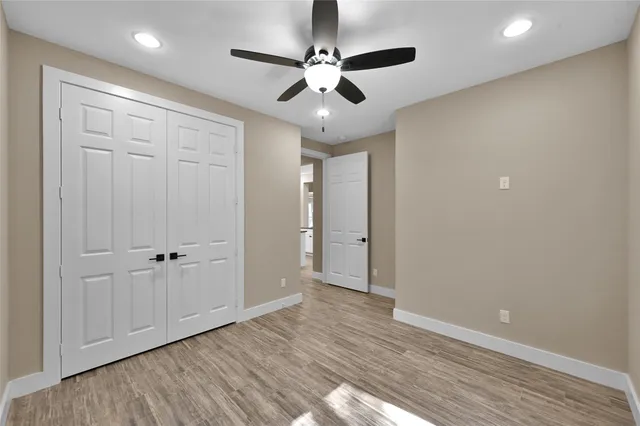 wooden floor in an empty room with a ceiling fan