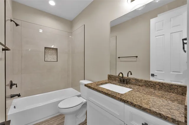 a bathroom with a granite countertop sink toilet and shower