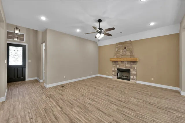 a view of empty room with wooden floor and fireplace