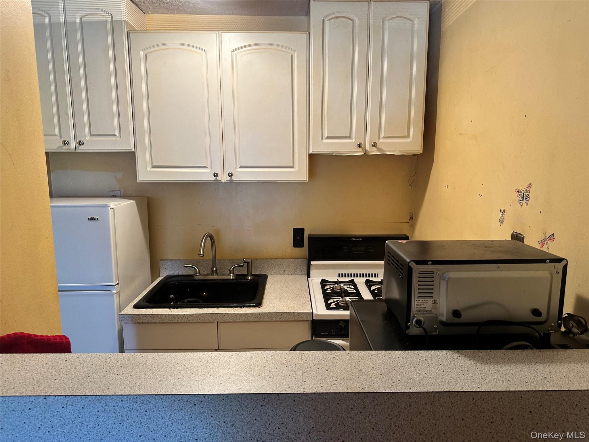 2201 Palmer Avenue, Unit 2F New Rochelle, NY 10801 - Photo 13 of 16 a kitchen with stainless steel appliances a stove a microwave and cabinets