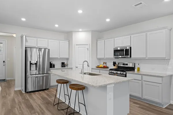 a kitchen with stainless steel appliances a refrigerator stove microwave and cabinets