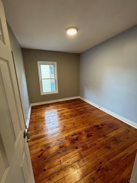 218 Vernon Street Worcester, MA 01607 - Photo 15 of 17 wooden floor in an empty room with a window