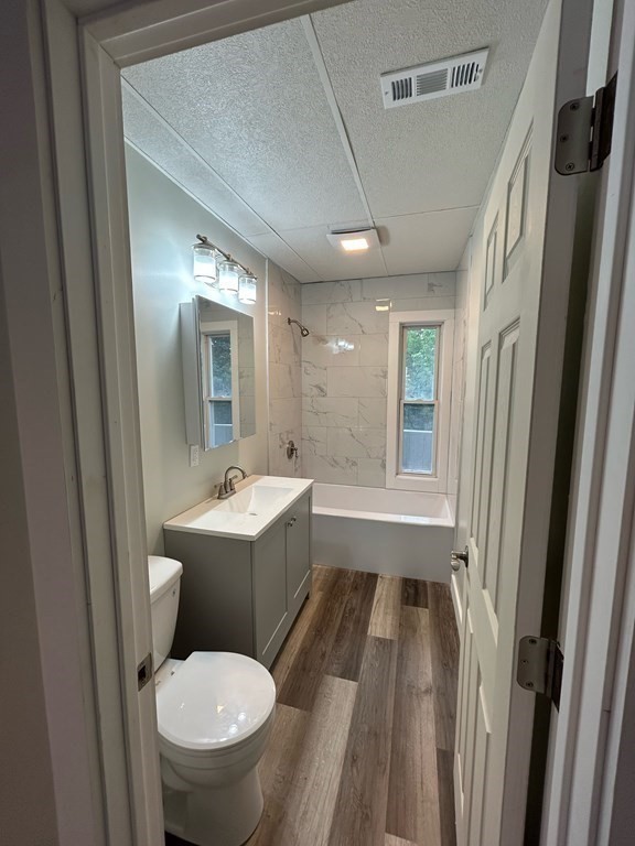 218 Vernon Street Worcester, MA 01607 - Photo 17 of 17 a bathroom with a sink toilet mirror vanity and bathtub