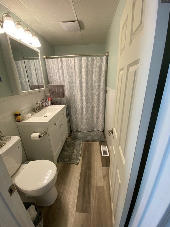 218 Vernon Street Worcester, MA 01607 - Photo 7 of 17 a bathroom with a sink a toilet a mirror and shower