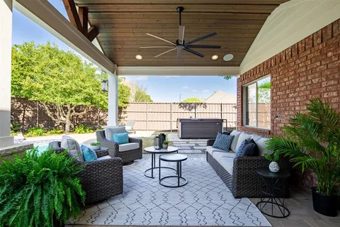 a living room with patio furniture and a potted plant