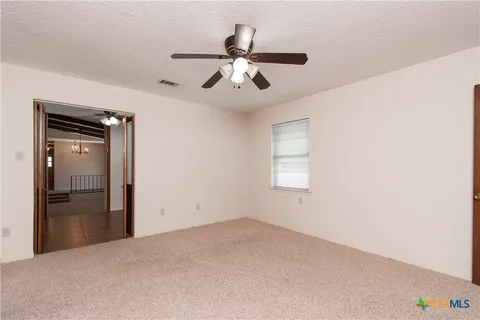 wooden floor in an empty room and a ceiling fan
