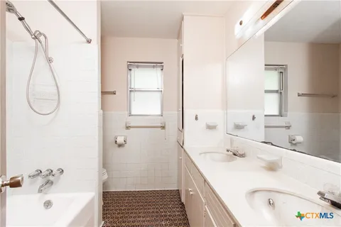 a bathroom with a tub a sink and a mirror