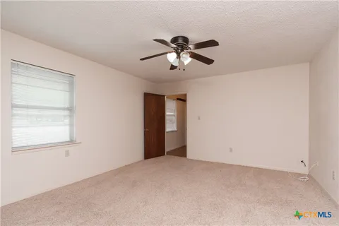 a view of a room with a ceiling fan and a window