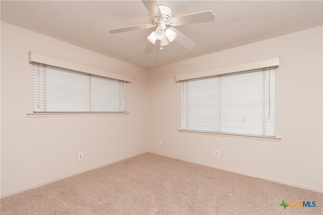 1 Timberline Drive Belton, TX 76513 - Photo 20 of 46 an empty room with a chandelier fan and windows