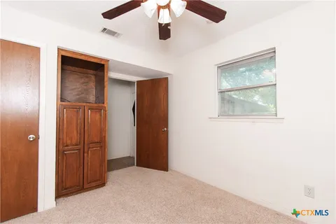 a view of a livingroom with a ceiling fan and window