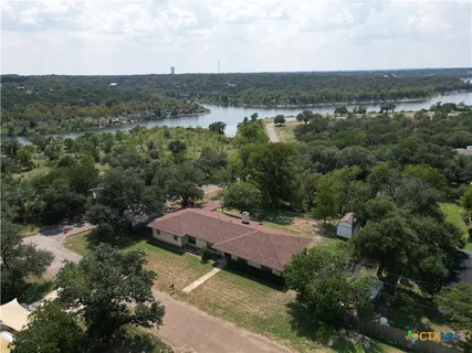 an aerial view of a house with a garden and lake view
