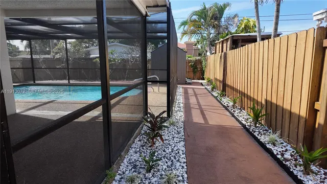 a backyard of a house with plants and palm tree