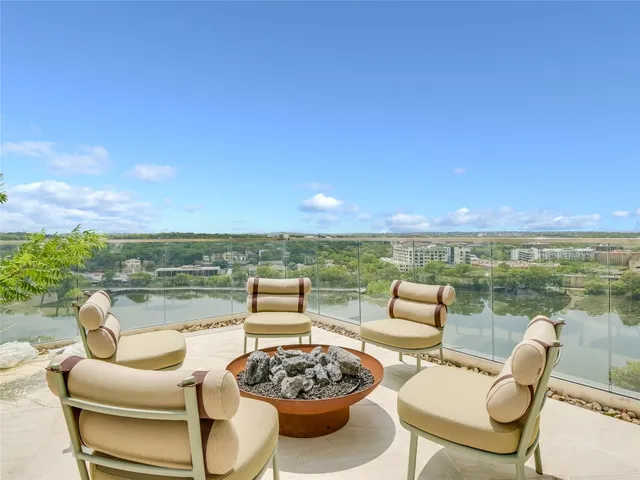 a view of a patio with couches potted plants and ocean view