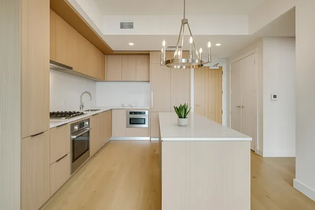 a kitchen with stainless steel appliances a chandelier