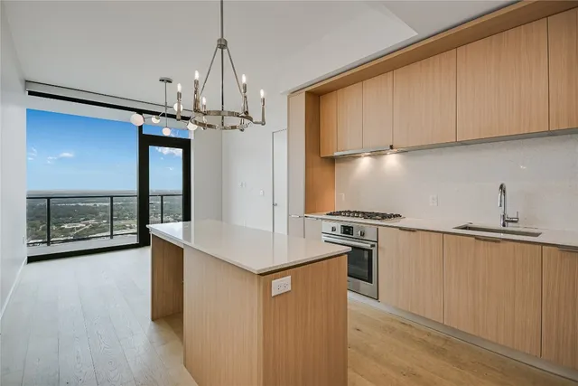 a kitchen with stainless steel appliances granite countertop a sink a stove and a refrigerator