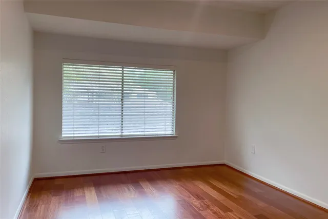 an empty room with wooden floor and a window