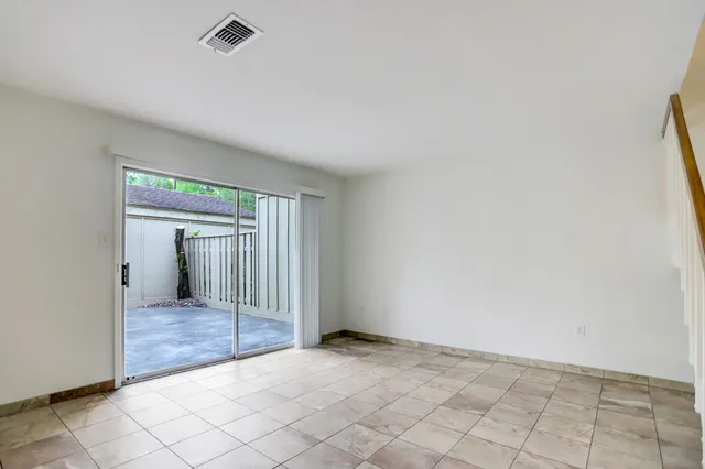 an empty room with wooden floor and mirror
