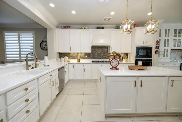 a kitchen with stainless steel appliances white cabinets and a sink