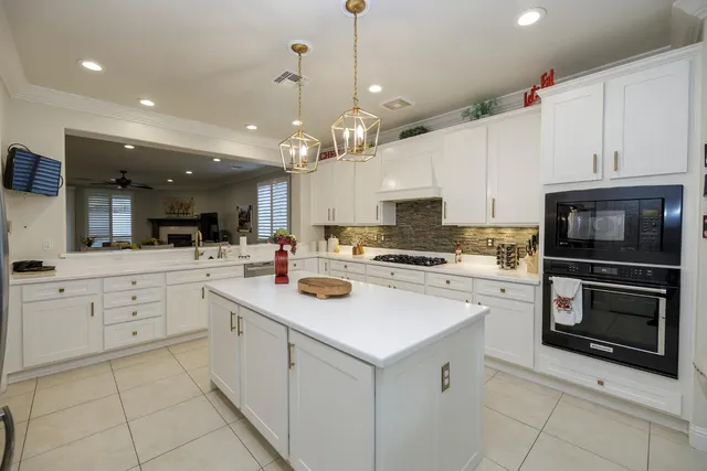 a kitchen with white cabinets and window