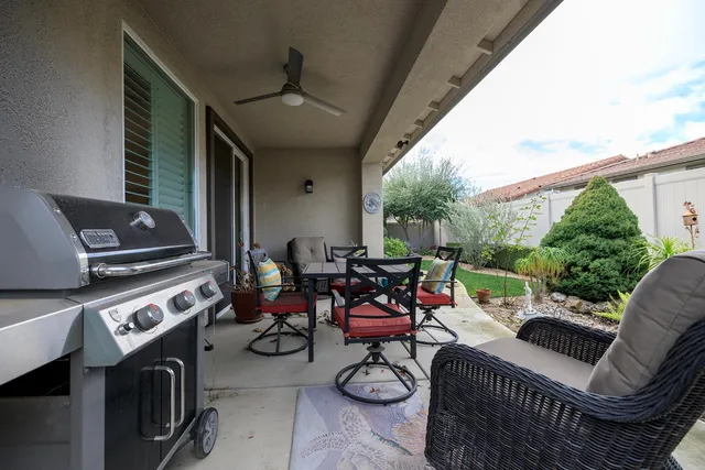 a view of a backyard with potted plants and a table and chairs