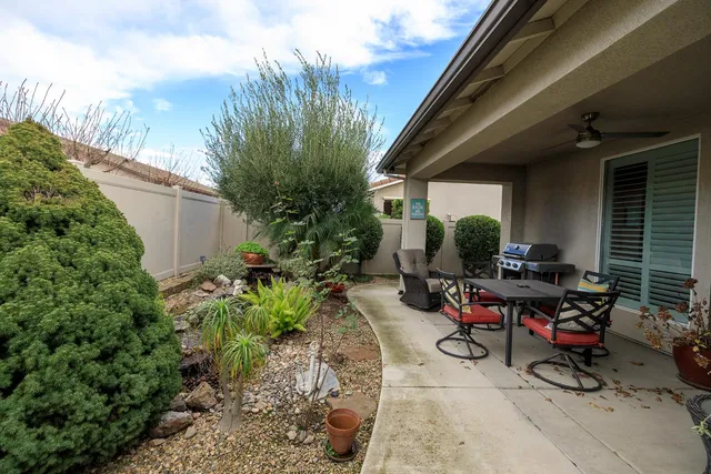 a backyard of a house with a table and chairs