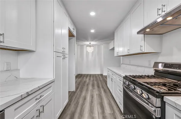 a kitchen with wooden floor and a stove top oven
