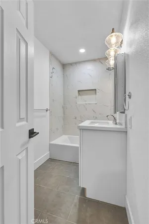 a bathroom with a sink a mirror and a bathtub