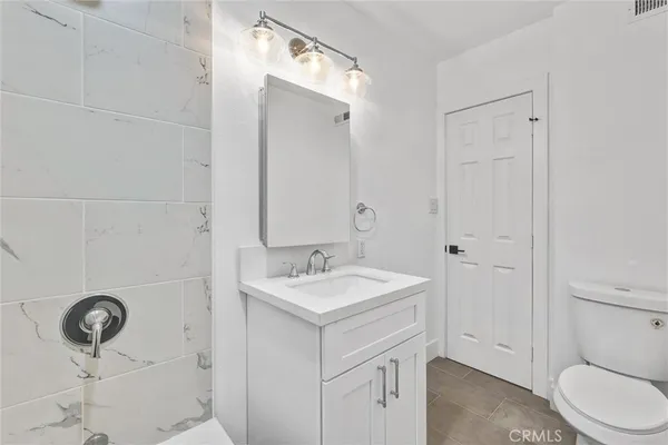 a bathroom with a sink a toilet and a mirror