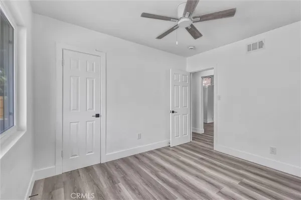 a view of an empty room with window and a ceiling fan