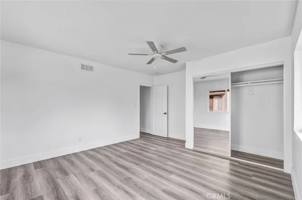 a view of a room with wooden floor and a ceiling fan