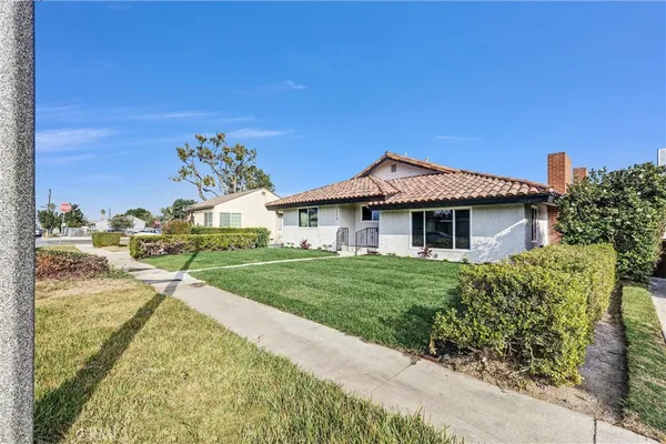 a front view of a house with a garden and yard