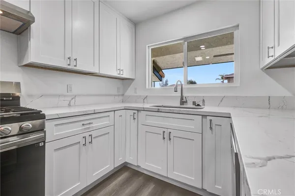 a kitchen with white cabinets and white appliances