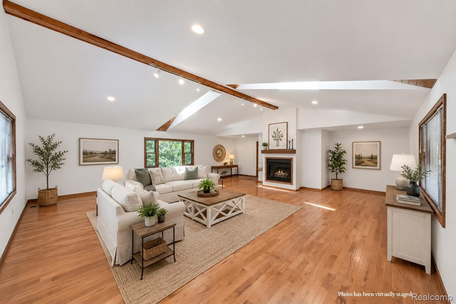 10201 Washburn Road Goodrich, MI 48438 - Photo 16 of 85 Vaulted ceilings with exposed wood beams, hardwood flooring, fireplace with wood mantel, recessed lighting, and large windows
