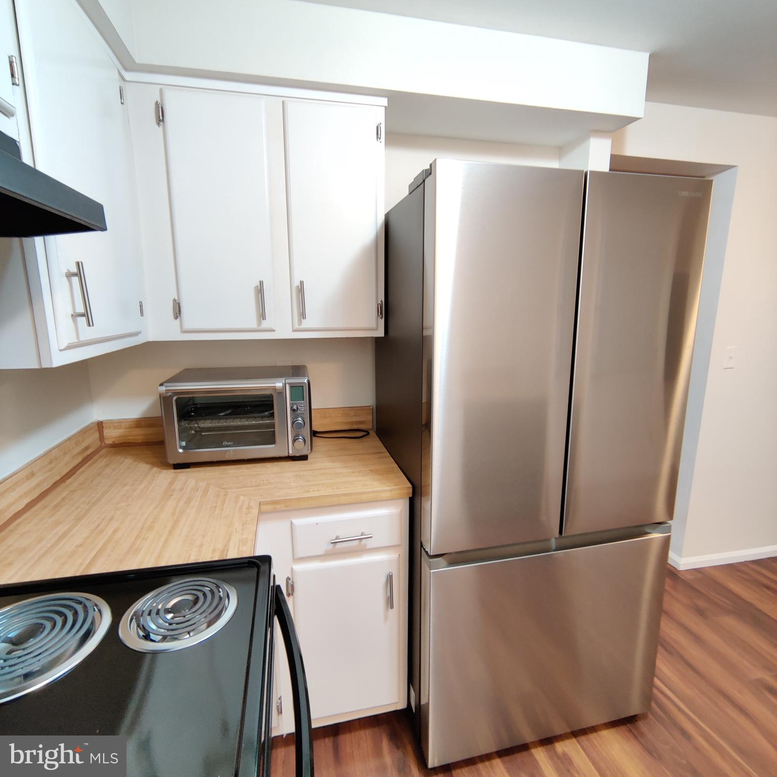 8317 Georgian Court Manassas, VA 20110 - Photo 5 of 15 a kitchen with a refrigerator and a stove