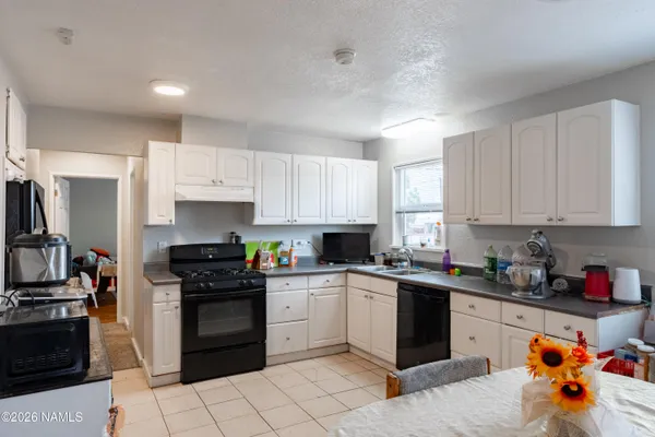 a kitchen with a sink a stove and cabinets