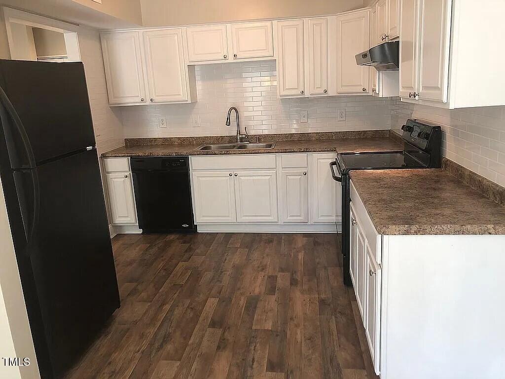 a kitchen with a sink a refrigerator and cabinets