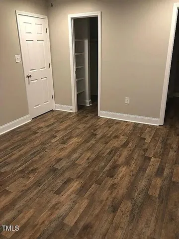an empty room with wooden floor and closet
