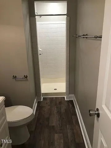 a bathroom with a toilet and a shower