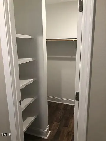 a view of walk in closet with empty racks