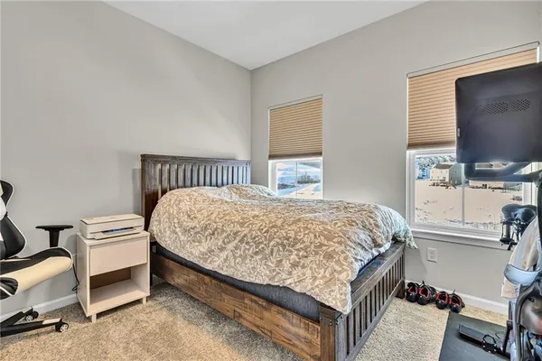 a bed sitting in a bedroom and tv