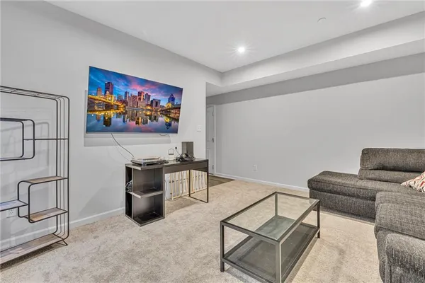 a living room with furniture a flat screen tv and a wall painting