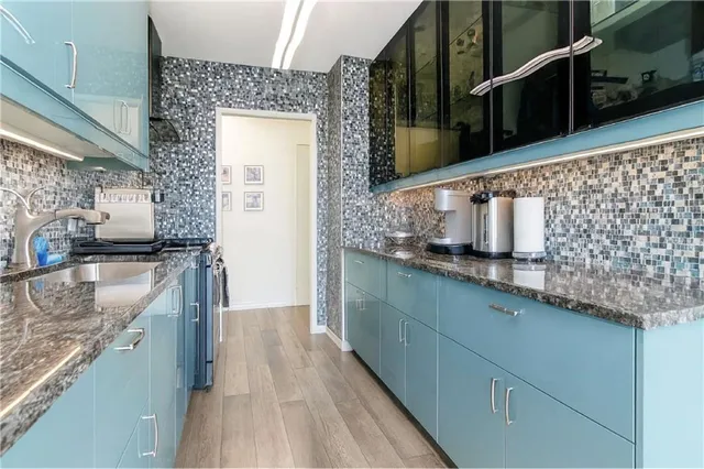 a kitchen with granite countertop a sink and a stove