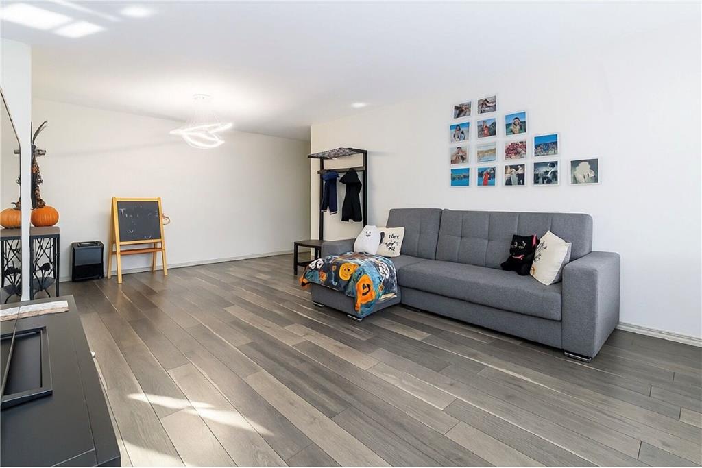 2652 Cropsey Avenue, Unit 9H Brooklyn, NY 11214 - Photo 19 of 23 a living room with furniture and a wooden floor