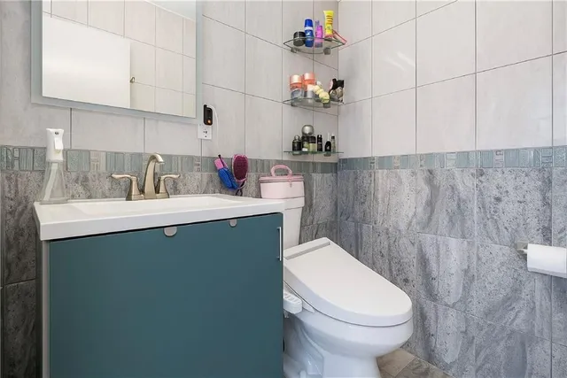 a bathroom with a sink vanity mirror and toilet