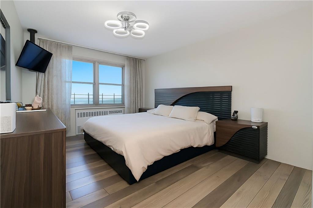 2652 Cropsey Avenue, Unit 9H Brooklyn, NY 11214 - Photo 4 of 23 a bedroom with a bed and a chandelier
