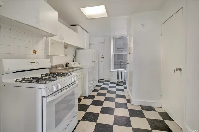 a kitchen with a stove a sink and a black cabinets
